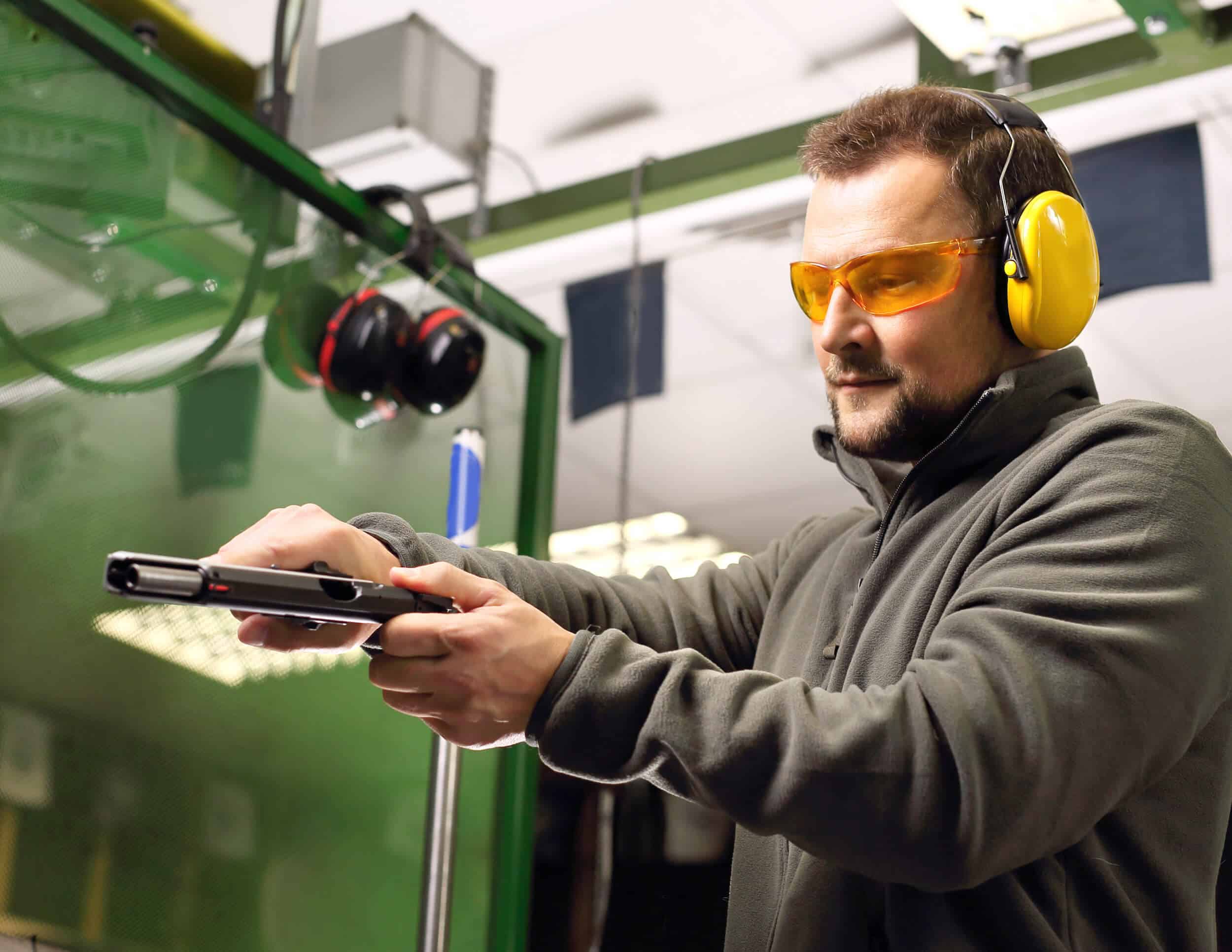 main loading a pistol at a shooting range